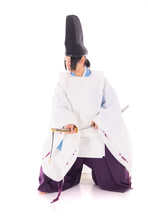 白い狩衣姿で抜刀する装束の男性、日本刀を構える