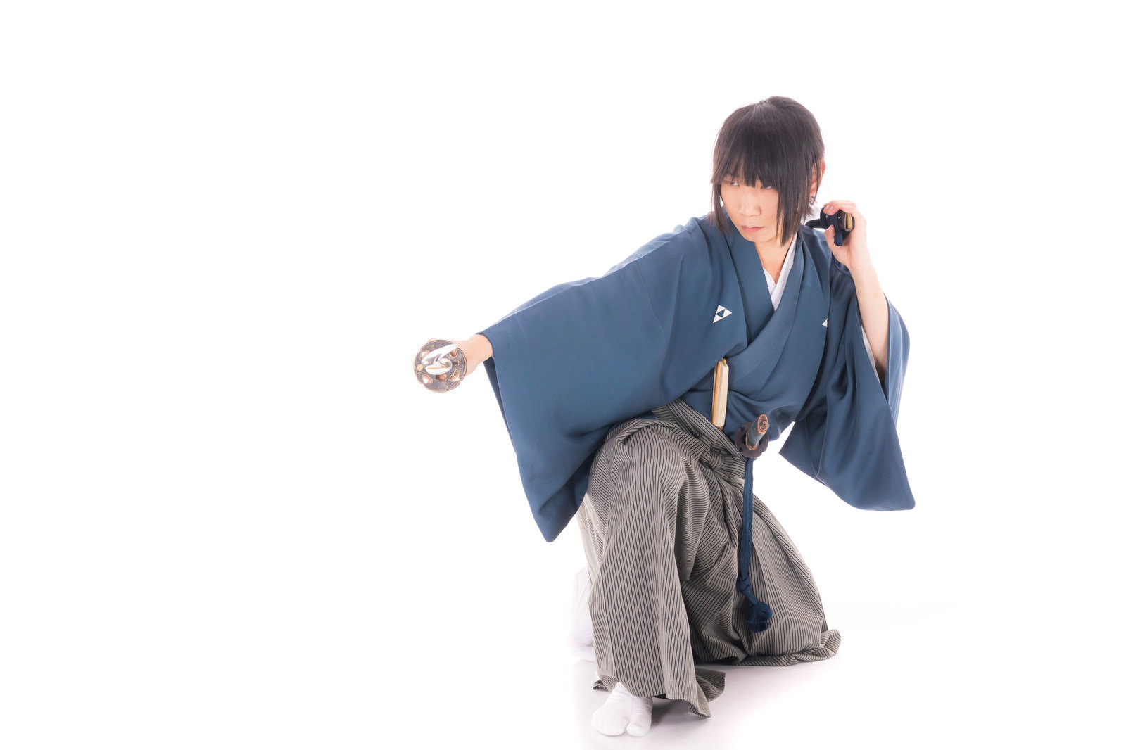 青い着物を着た侍が片膝をついて刀の鞘を武器として構えるポーズ［モデル：まーこ］