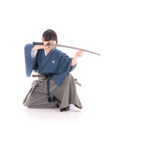 刀を構え敵を見据える侍の抜刀姿勢、日本刀を握る武士の写真