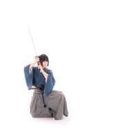 真剣を抜く剣士の瞬間 青い着物の男性が居合で刀を抜き放つの写真