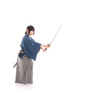 ポニーテール姿で日本刀を抜刀する侍の凛々しい姿勢の写真