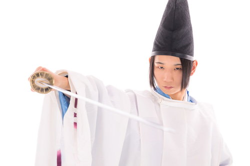 白い狩衣を身に纏い刀を抜く剣士の瞬間を捉えた時代劇写真