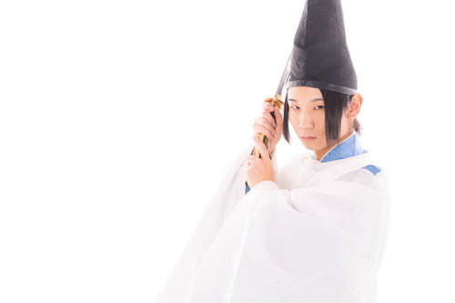 白い狩衣で太刀を抜刀し構える男性