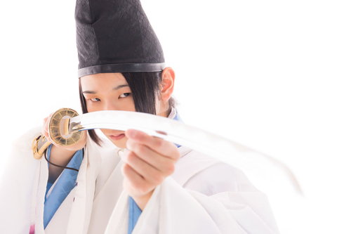 白い狩衣の剣士が鋭い視線で太刀を構える姿勢