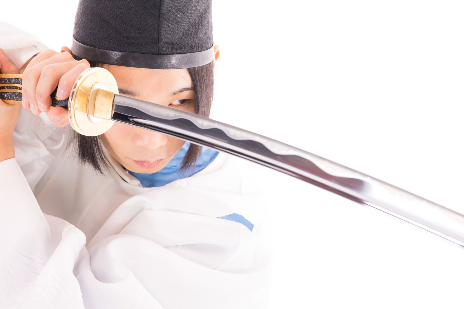 白い狩衣を着た剣士が太刀を構え剣先を見つめている様子［モデル：まーこ］