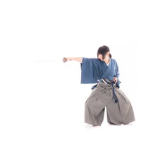 居合斬りの型を決める侍の動作を捉えた武道の写真