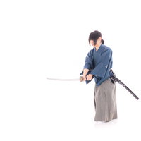 青い着物姿で刀を振り下ろす侍の抜刀ポーズの写真