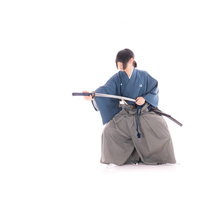 紺色の袴姿で刀を納刀する侍の武道動作と日本刀の伝統の写真