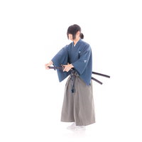 腰に差した刀を整える侍の姿勢の写真