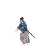 青い着物の袴姿で袈裟斬りする侍の抜刀動作の写真