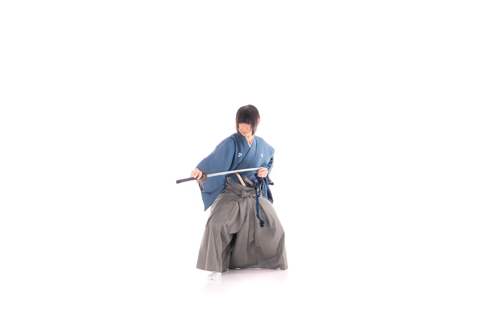 グレーの袴を着て刀を横に構える侍の男性［モデル：まーこ］