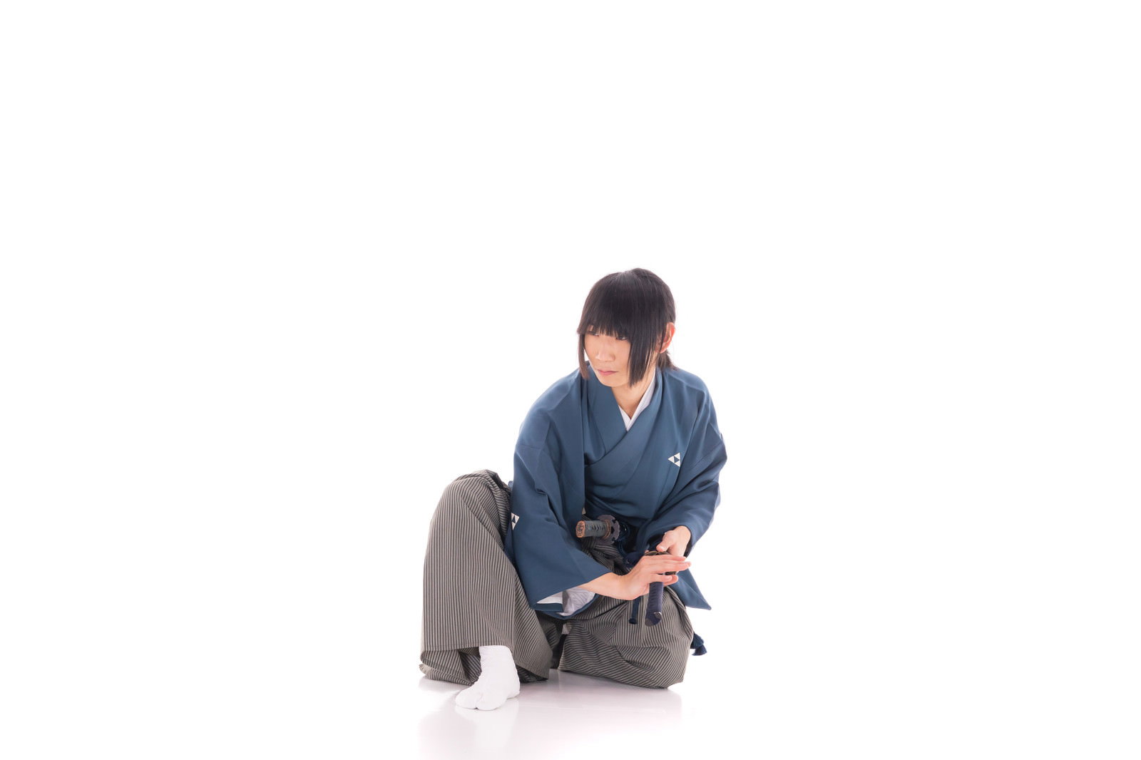 青い着物を着た侍が刀を手に低い姿勢で構えている様子［モデル：まーこ］
