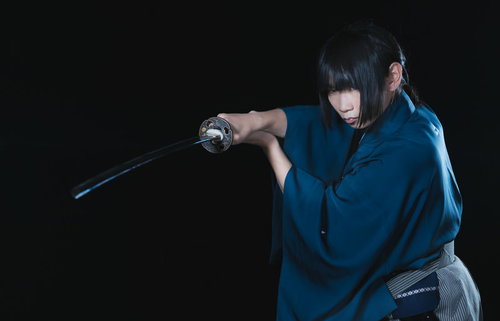 暗闇の中で日本刀を抜く侍の一瞬、緊迫した戦闘シーン