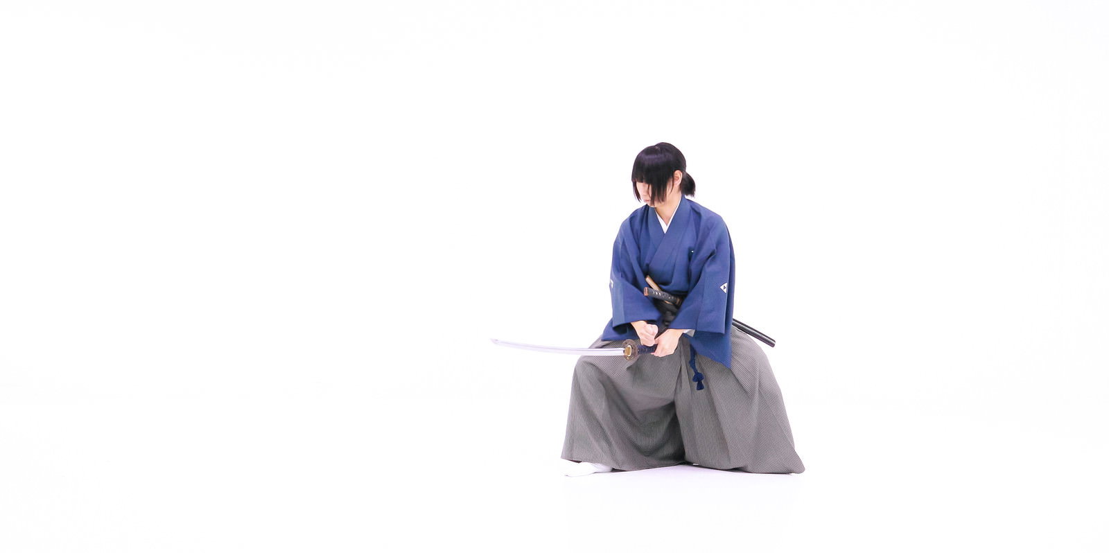 紫の着物を着た侍が日本刀で血振るいの構えをとっている［モデル：まーこ］