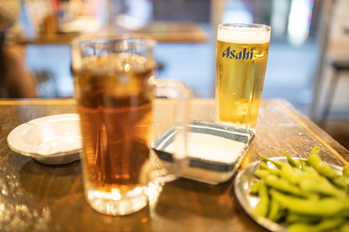 木のテーブルに並ぶとりあえずの生ビールとウーロンハイ