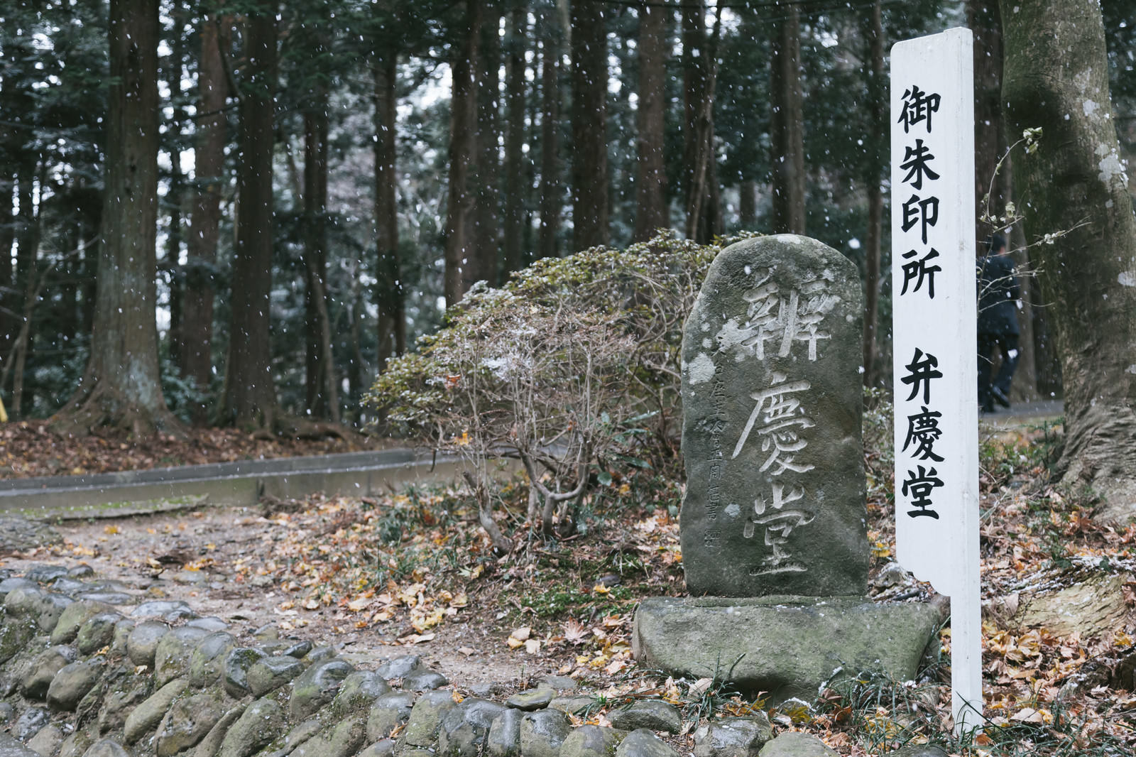 雪の境内に立つ中尊寺弁慶堂御朱印所の白い立札