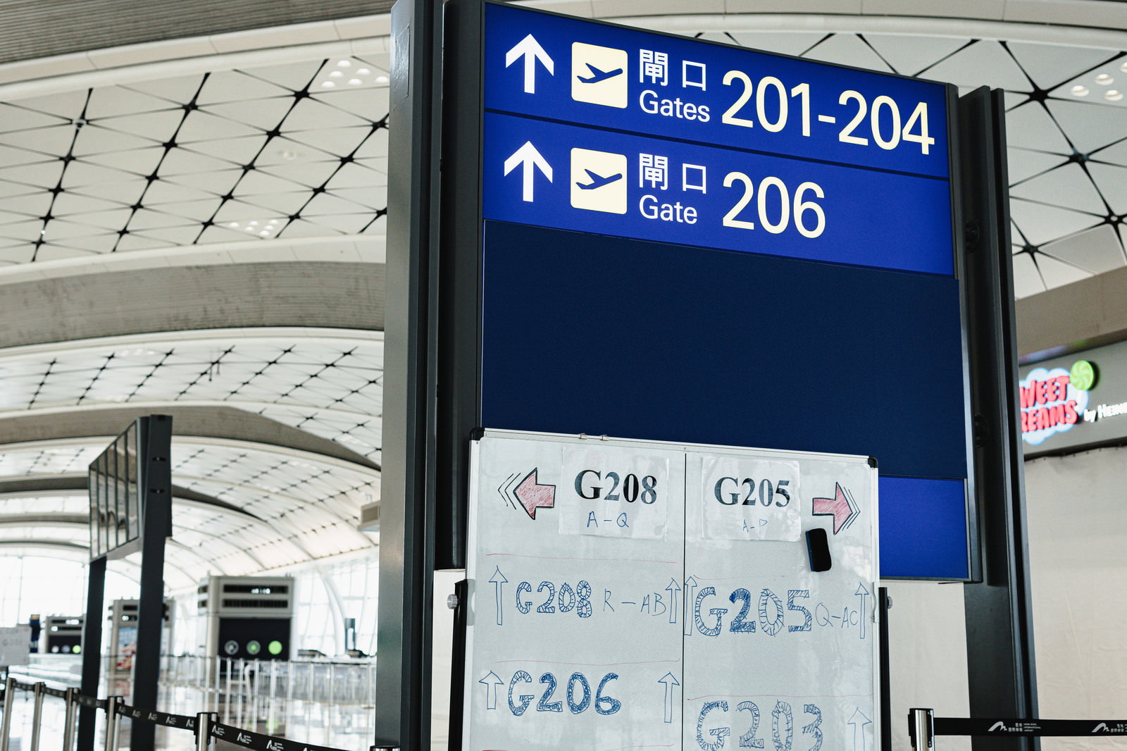 空港の搭乗口案内板とPCRエリアを示す手書きの案内紙