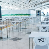 空港の隔離エリアに並ぶテーブルと椅子、待機ゲートエリアの写真
