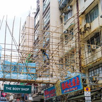 香港の街で見かける竹の足場と看板が組まれた建物の写真