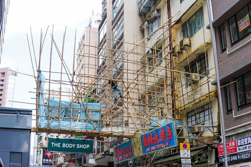 香港の街で見かける竹の足場と看板が組まれた建物