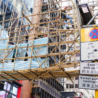 香港の街中で竹足場を組む職人の高所作業風景の写真