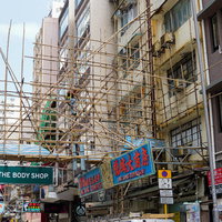 香港街で見かける竹製の足場と看板、建設工事の風景の写真