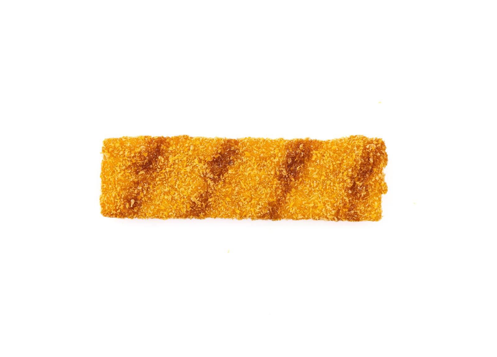 ソースがかかった黄色い揚げたカツ型の駄菓子