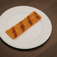 白い皿の上に置かれたソース味のカツのお菓子の写真