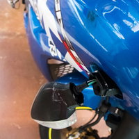 バイクのウインカーが折れて破損した状態、配線露出の写真
