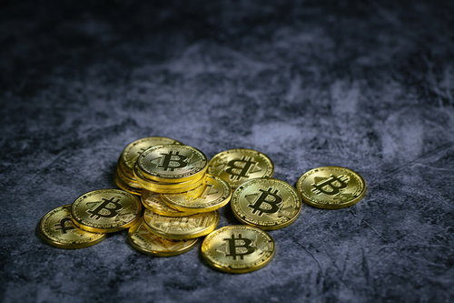 黄金色に輝くビットコインのコイン、暗号通貨投資イメージ