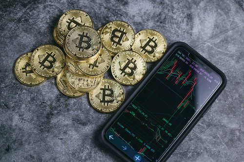 積まれたビットコインと横に置かれたスマートフォン