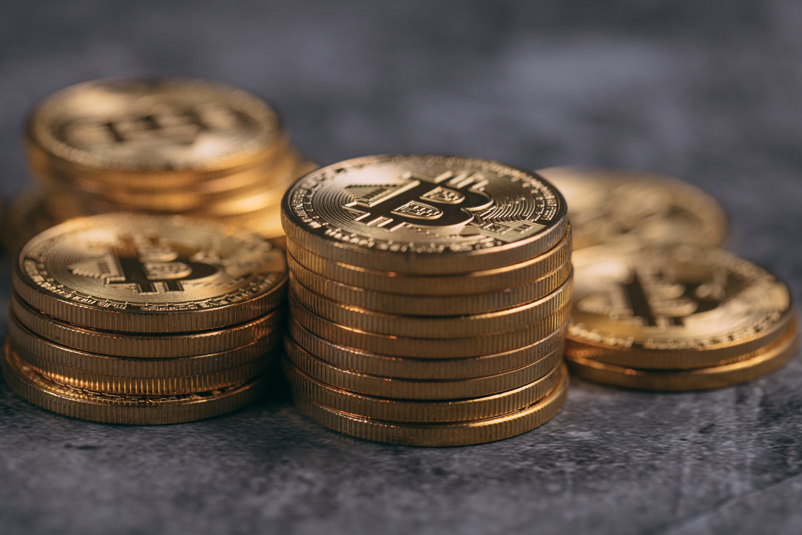 金色に輝くビットコインが複数枚重ねて置かれている様子