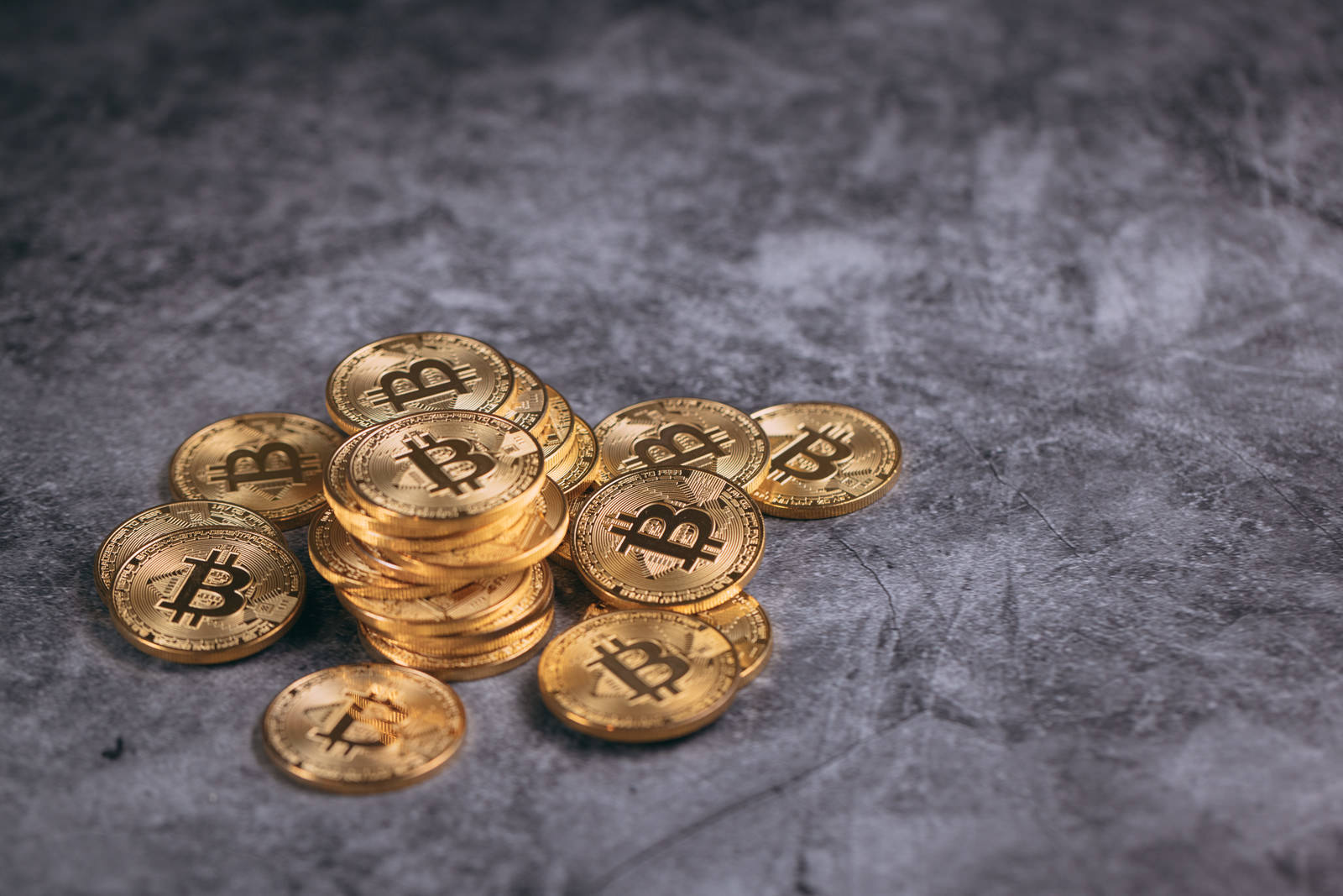 金色のビットコインコインが複数枚重なって置かれている様子