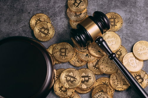 散らばったビットコインと木製のガベル（小槌）