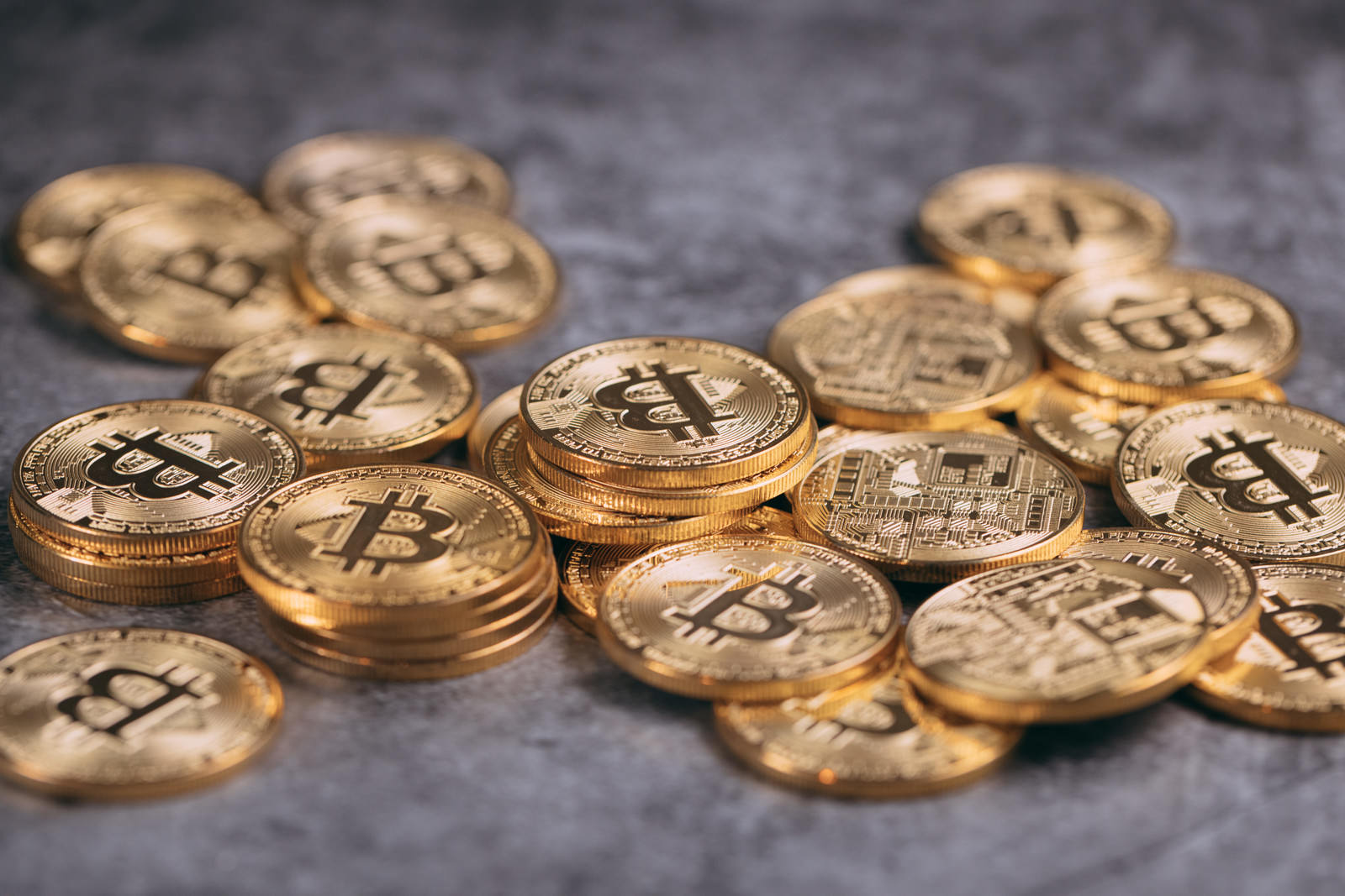石の床に散らばる金色のビットコインコイン群