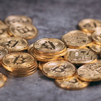 石の床に散らばる金色のビットコインの写真