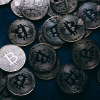 暗い背景で一枚だけ輝くビットコイン、仮想通貨投資の写真