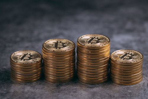 積み重ねられた現物のビットコイン、金色に輝く通貨資産