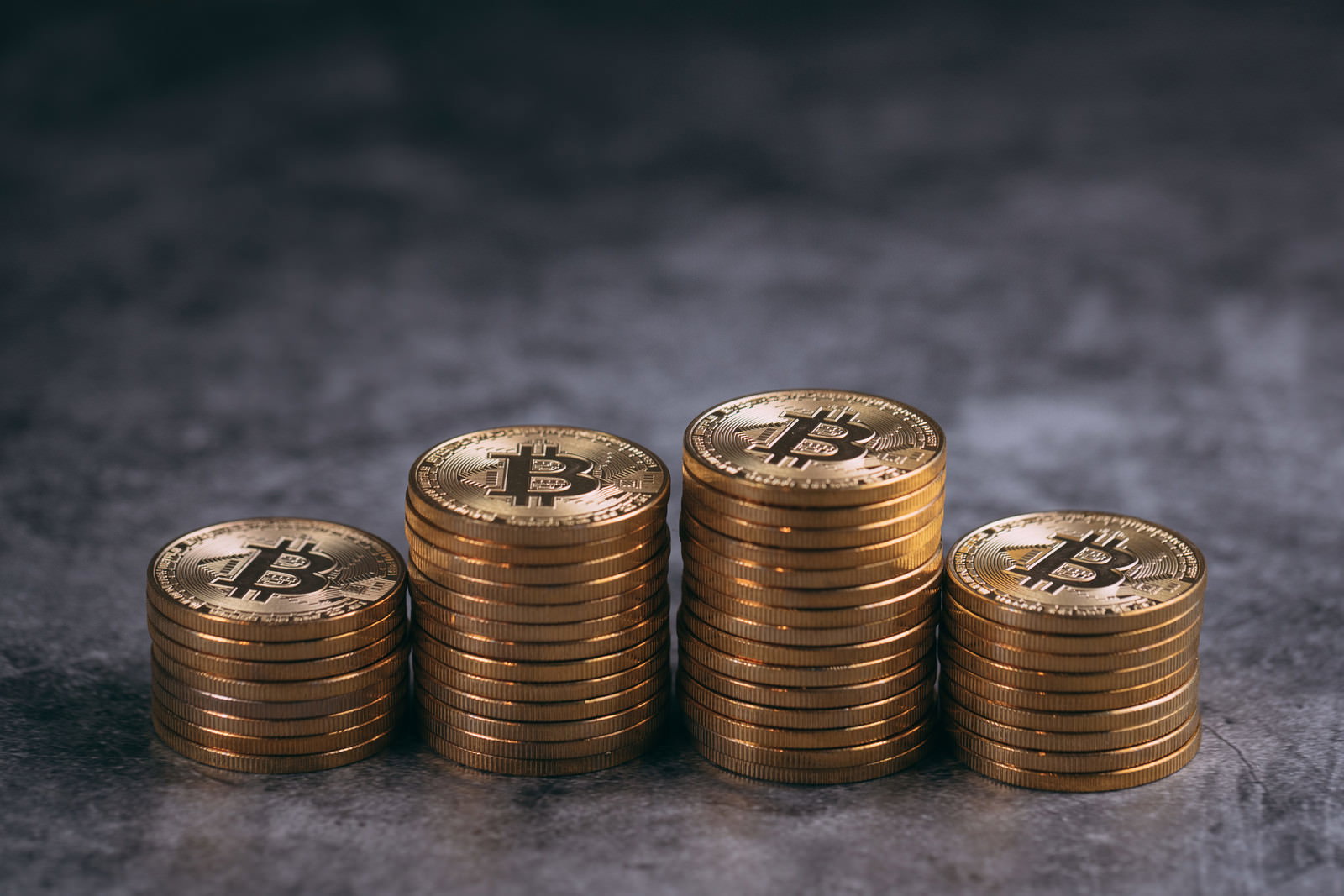金色のビットコインコインが複数枚積み上げられている