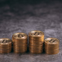 所有しているビットコインの金色コイン積み重ねの写真