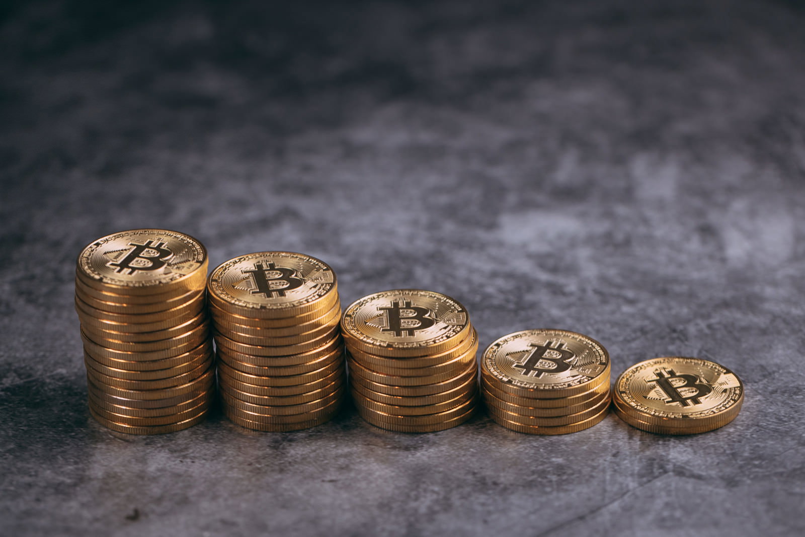 金色のビットコインコインが階段状に積み重ねられている様子