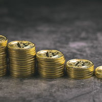 膨れ上がるビットコイン市場を表現した階段状の金貨の積み重ねの写真