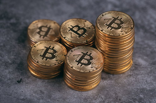 金色に輝く積み上げたビットコインの山と暗号資産