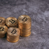 金色に輝く複数のビットコインを一山高く積み上げた様子の写真