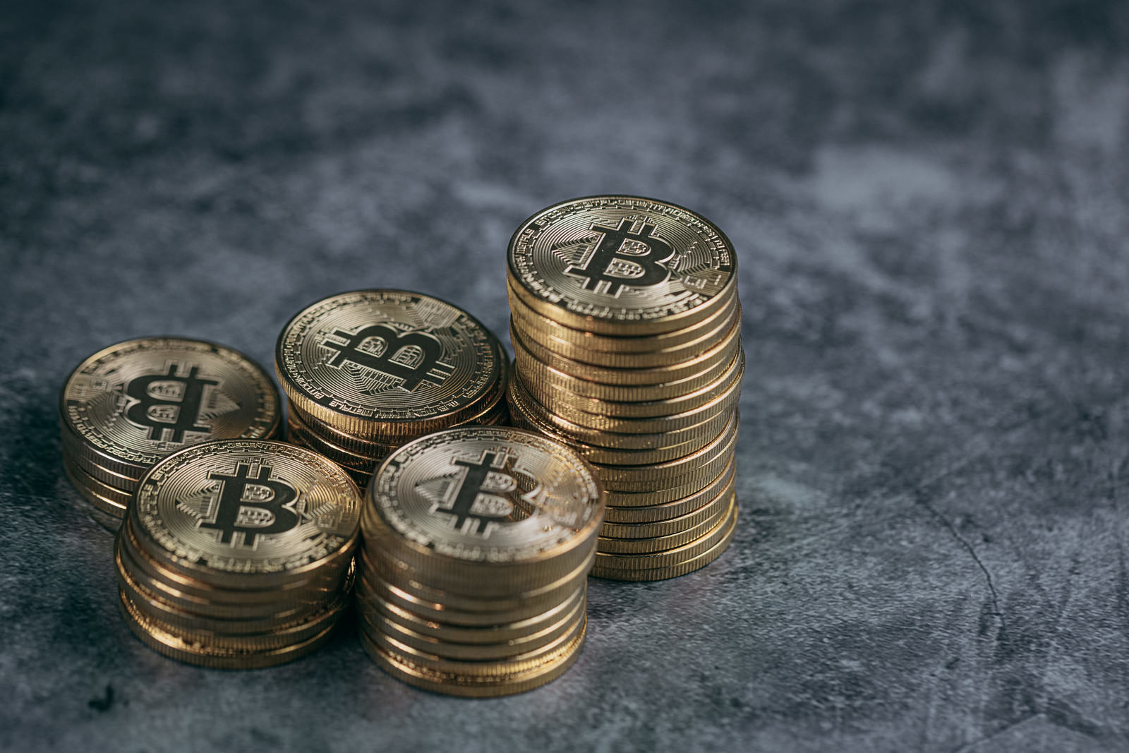 暗い背景に積み重ねられた金色のビットコインコイン