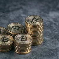 積み重ねられたビットコインの金貨と資産の写真