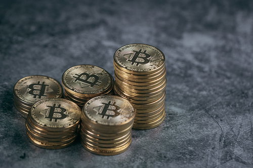 積み重ねられたビットコインの金貨と資産
