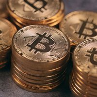 黄金色に輝く積み上がったビットコインの表面の写真