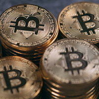 潤沢なビットコインの積み重なる金色のコインの写真