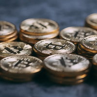 ゴールド色に輝く積み上がったビットコインの写真